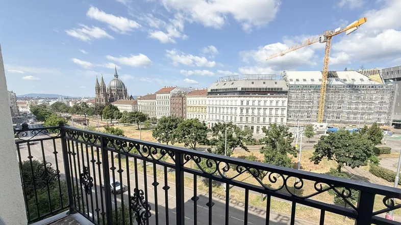 Blick vom Balkon auf die Stadt mit historischer Architektur und einer Baustelle im Hintergrund.