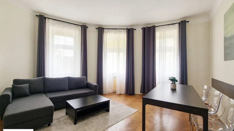 Helles Wohn- und Esszimmer mit Fischgrätparkett, bequemer Sitzecke und Esstisch für gesellige Runden.