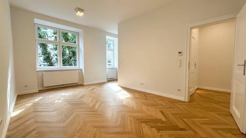Helles Zimmer mit Fischgrätparkett und großen Fenstern, frisch renoviert und bezugsfertig.