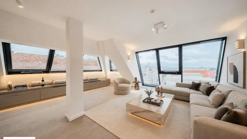 Helles, modern eingerichtetes Wohnzimmer mit großen Dachfenstern und weitem Stadtblick.