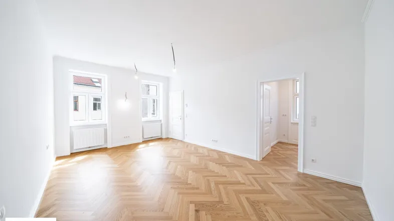 Helles, frisch renoviertes Zimmer mit Fischgrätparkett und hohen Decken, bereit zur individuellen Gestaltung.