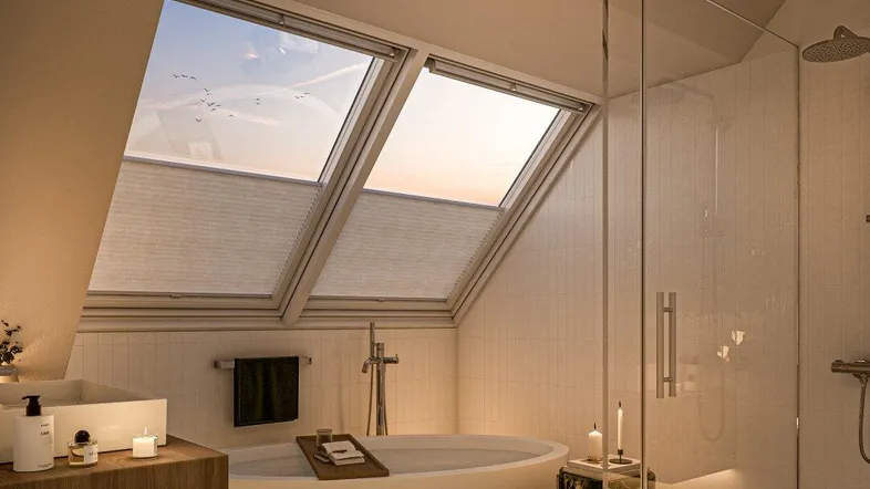 Modernes Badezimmer im Dachgeschoss mit freistehender Badewanne, begehbarer Dusche und Dachfenstern.