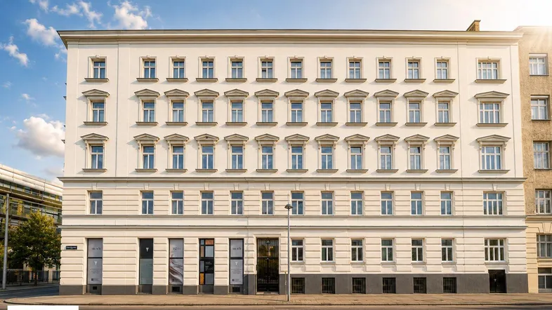 Klassische Fassade eines Altbaus mit vielen Fenstern und Geschäften im Erdgeschoss.