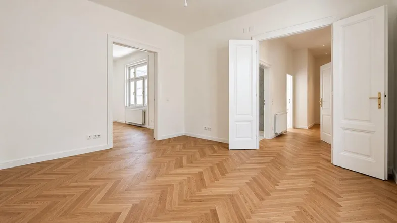 Helles Zimmer mit Fischgrätparkett und hohen Flügeltüren, das vielseitig nutzbar ist.