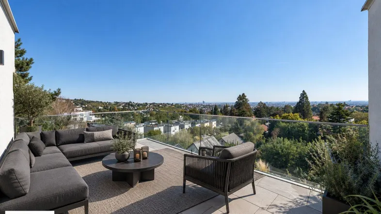 Große, möblierte Terrasse mit moderner Lounge-Gruppe und weitem Blick über die Stadt und grüne Umgebung.