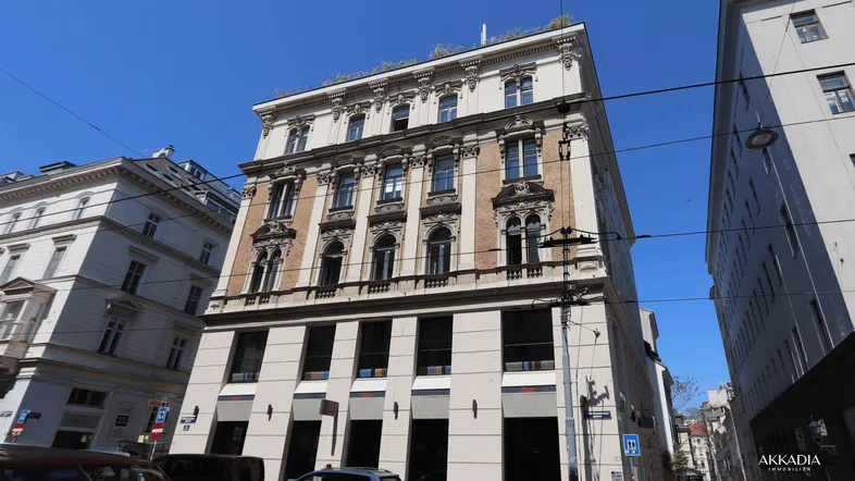 Historisches Gebäude mit klassischer Architektur und großen Fenstern in einer städtischen Umgebung.