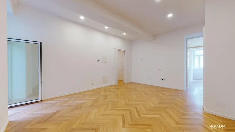 Helles, leeres Zimmer mit Fischgrätparkett und Einbaustrahlern, bereit zur individuellen Gestaltung.