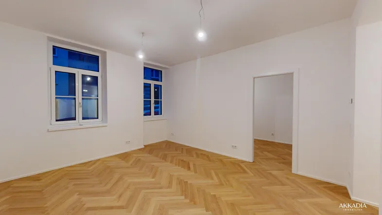 Helles Zimmer mit Fischgrätparkett und weißen Wänden, bereit für individuelle Gestaltung.
