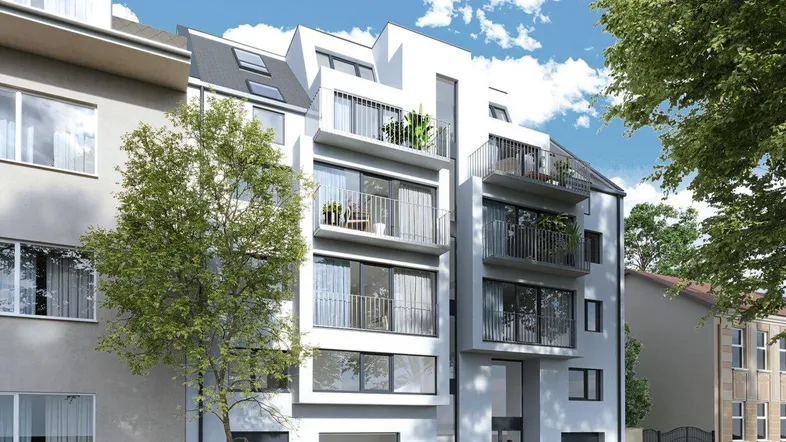 Moderne Architektur eines Mehrfamilienhauses mit Balkonen und großen Fenstern in städtischer Umgebung.
