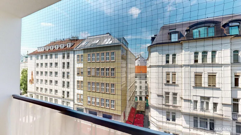 Blick vom Balkon auf die umliegenden Gebäude und die Stadtlandschaft unter blauem Himmel.