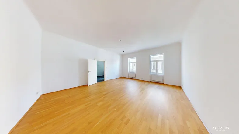 Helles, leeres Zimmer mit Parkettboden und weißen Wänden, bereit zur individuellen Gestaltung.