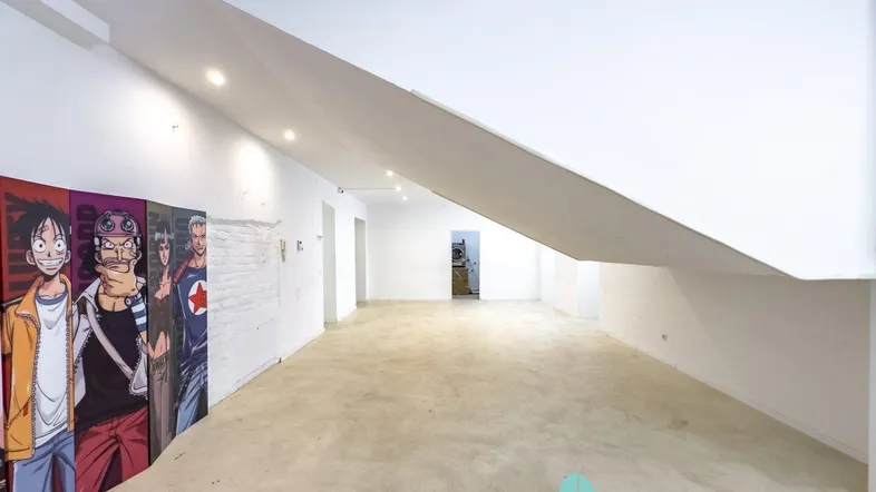 Geräumiger, leerer Innenraum mit Betonboden, weißen Wänden und moderner Beleuchtung, ideal für gewerbliche Nutzung.