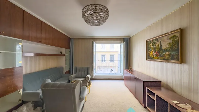 Geräumiges Wohnzimmer mit Teppichboden, Holzvertäfelung und Zugang zu einem französischen Balkon.