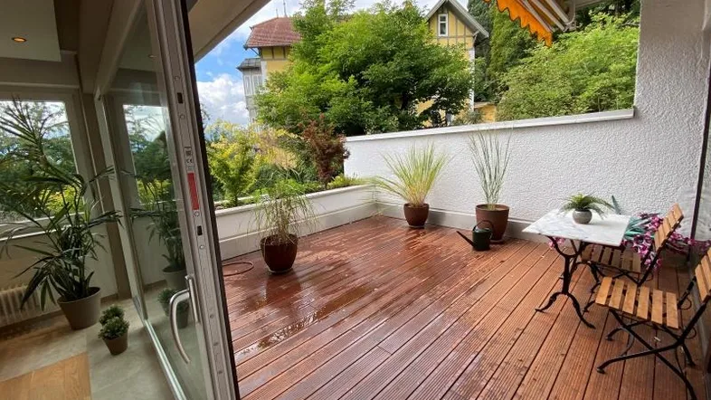 Große Holzterrasse mit Sitzgelegenheiten und Blick auf die umliegende Natur, ideal zum Entspannen.