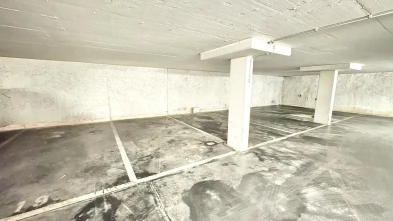 Geräumige Tiefgarage mit markierten Stellplätzen und Betonboden.