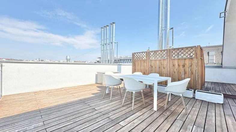 Geräumige Dachterrasse mit Holzboden, Esstisch und Stühlen, ideal für Mahlzeiten im Freien mit Stadtblick.