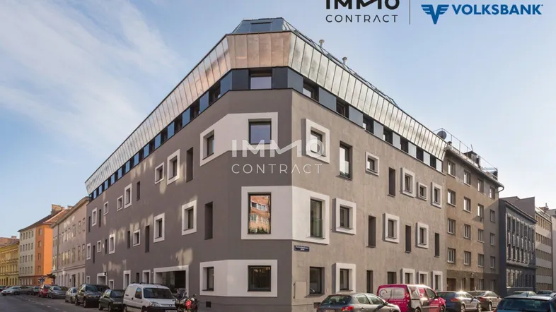 Modernes Eckgebäude mit zeitgenössischer Architektur, großen Fenstern und gepflegter Fassade in urbaner Umgebung.