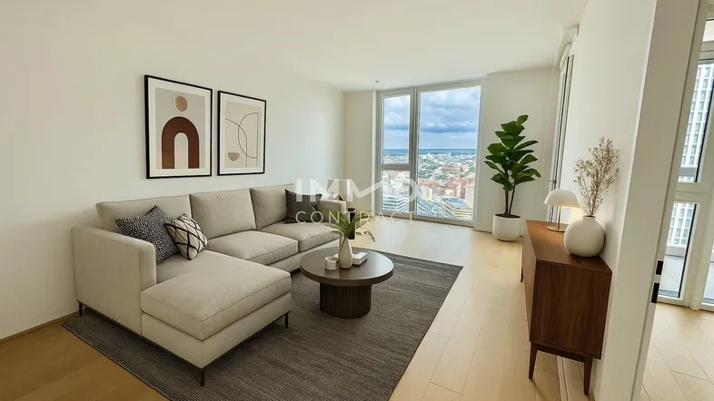 Modern eingerichtetes Wohnzimmer mit beigem Sofa, Holzboden und Panoramafenstern mit Stadtblick.