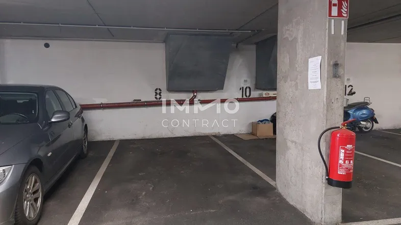 Tiefgaragenstellplatz in einer gut beleuchteten und funktionalen Parkgarage mit Brandschutzvorrichtungen.