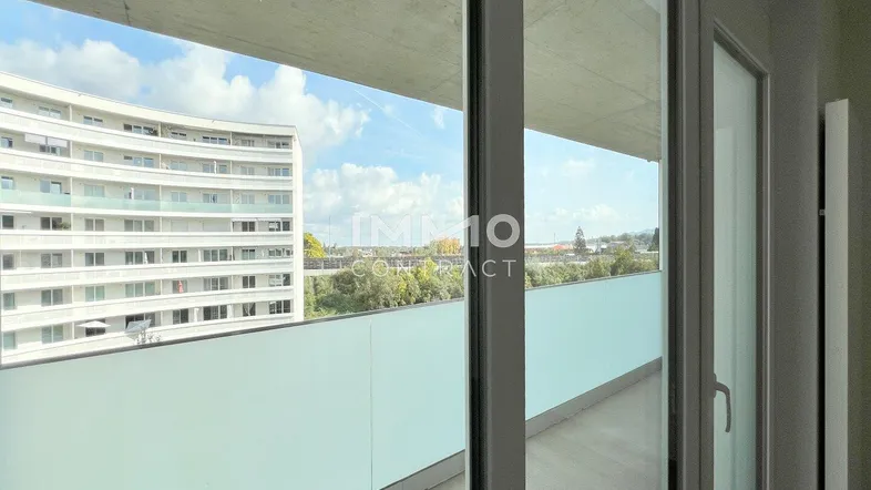 Geräumiger Balkon mit Blick auf die umliegenden Gebäude und viel Grün.