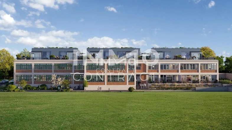Moderne Wohnanlage mit ansprechender Architektur, großen Fenstern und begrüntem Rasenbereich.