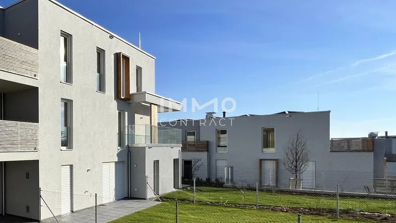 Moderne Wohngebäude mit Balkonen und Grünflächen unter blauem Himmel, die eine angenehme Wohnatmosphäre schaffen.