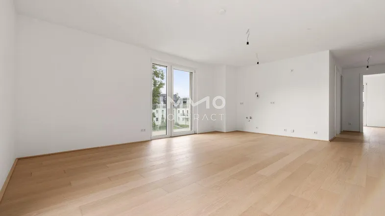 Geräumiges, helles Zimmer mit Holzboden und großen Fenstern, ideal für individuelle Gestaltung.