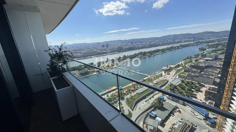Geräumiger Balkon mit Glasbrüstung bietet einen atemberaubenden Blick auf die Donau und die Stadt.