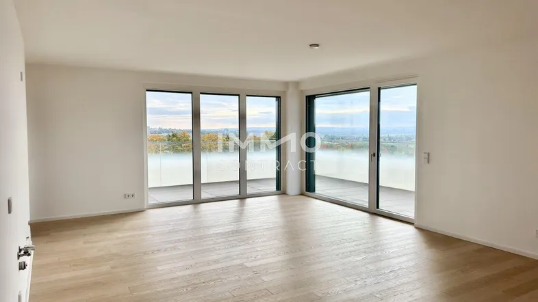 Helles und geräumiges Wohnzimmer mit großen Fenstern und Zugang zum Balkon.