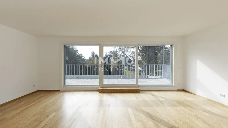Helles Wohnzimmer mit Holzboden und Zugang zu einer großen Terrasse.