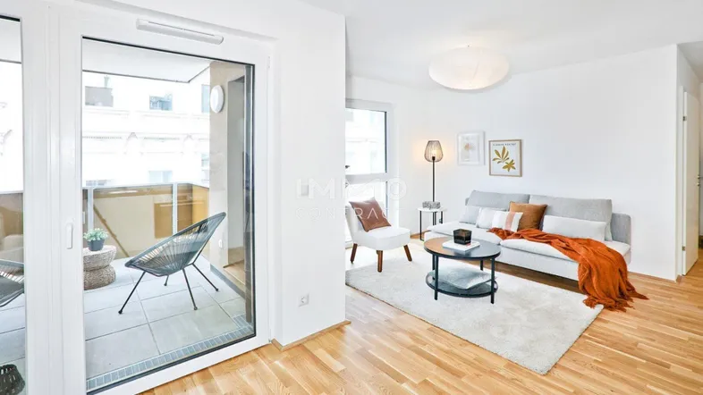Helles Wohnzimmer mit Parkettboden, moderner Einrichtung und Zugang zu einem Balkon.