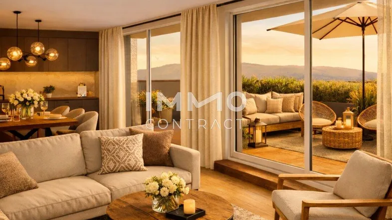 Helles, offenes Wohn-Esszimmer mit Zugang zu einer großen Terrasse und Bergblick bei Sonnenuntergang.
