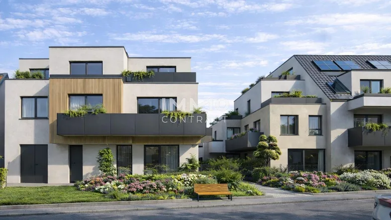 Moderne Wohngebäude mit begrünten Dächern und Balkonen, umgeben von gepflegten Grünflächen und einer Straße.