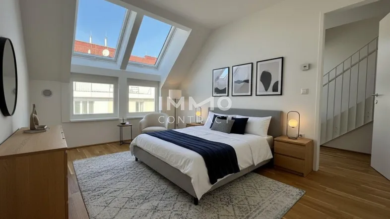 Helles Schlafzimmer mit Holzboden, großen Dachfenstern und modernem Mobiliar unter Schrägdach.