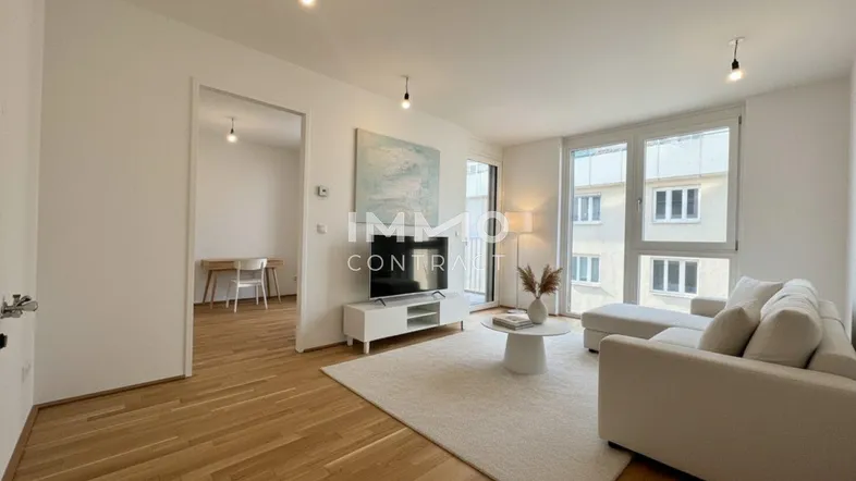 Helles Wohnzimmer mit Parkettboden, großen Fenstern und modernem Interieur.