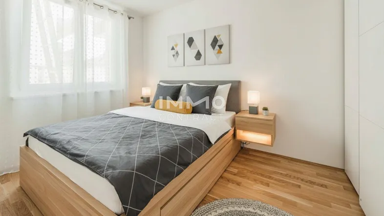 Helles Schlafzimmer mit modernem Holzbett, Parkettboden und großen Fenstern, stilvoll eingerichtet.