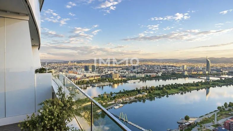 Großer Balkon mit atemberaubendem Blick auf die Stadt und den Fluss bei Sonnenuntergang.