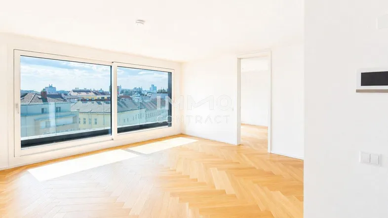 Helles Wohnzimmer mit Fischgrätparkett und großen Fenstern, die einen weiten Stadtblick bieten.