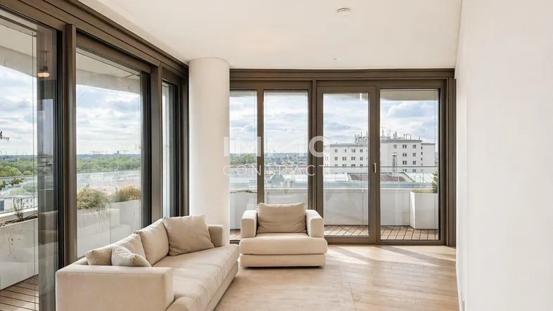Helles Wohnzimmer mit großen Schiebetüren, Holzboden und Blick auf die Stadt.