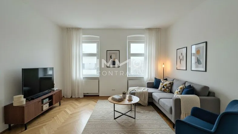 Helles Wohnzimmer mit Fischgrätparkett, modernem Sofa und großen Fenstern für viel Tageslicht.