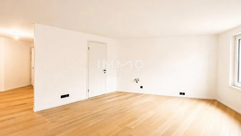Helles, leeres Zimmer mit Parkettboden und weißen Wänden, bereit zur individuellen Gestaltung.