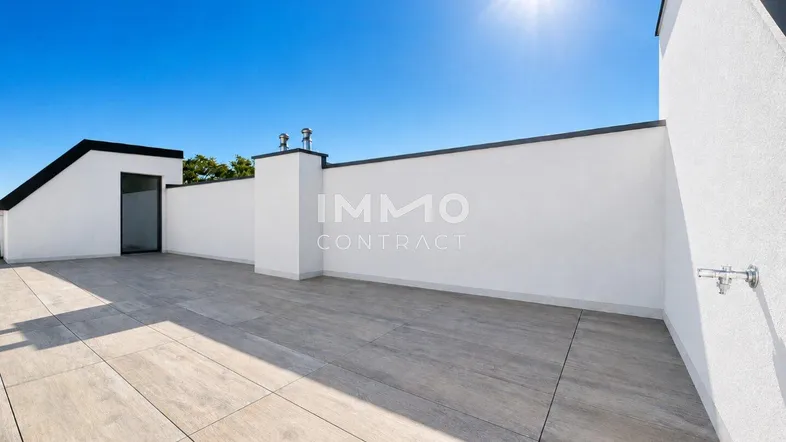 Große, sonnige Dachterrasse mit hellen Fliesen und weißer Brüstung, ideal zum Entspannen im Freien.