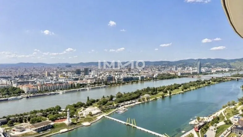 Panoramablick über die Stadt mit Fluss und Brücken unter blauem Himmel.