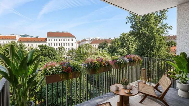 Möblierter Balkon mit Blumenkästen und Blick auf die Stadt und viel Grün.