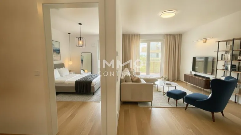Helles Wohnzimmer mit Holzboden, modernen Möbeln und Zugang zu einem Schlafzimmer und Balkon.