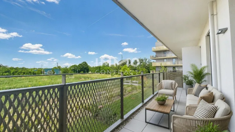Möblierter Balkon mit Fliesenboden, weitem Blick ins Grüne und modernen Sitzgelegenheiten.
