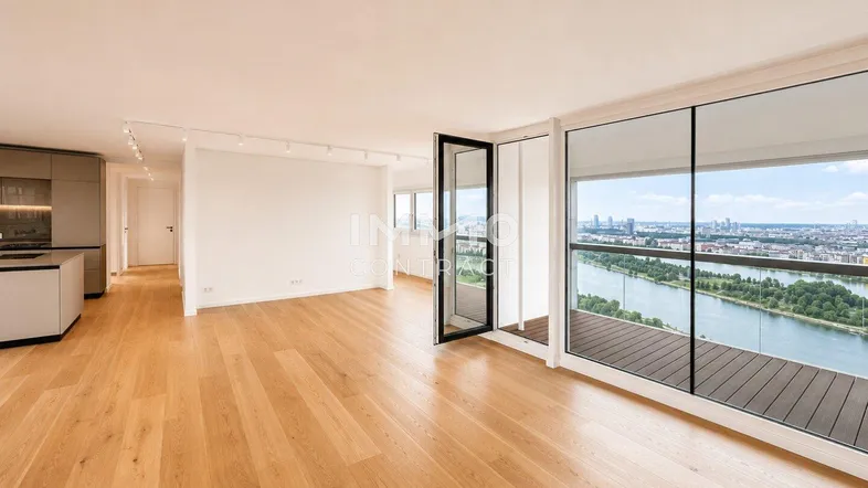 Helles, offenes Wohnzimmer mit Holzboden und raumhohen Fenstern, die einen weiten Stadtblick bieten.