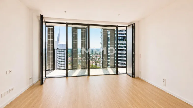 Helles Wohnzimmer mit Holzboden und raumhohen Fenstern, die einen weiten Blick auf die Stadt bieten.