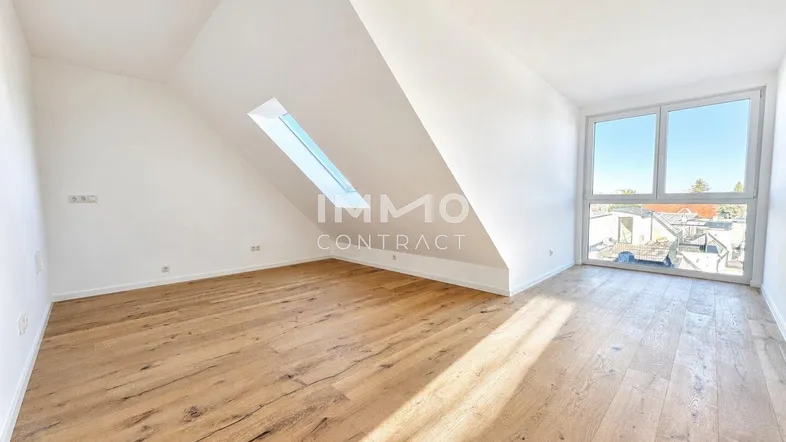 Helles Dachzimmer mit Holzboden, großen Fenstern, Dachschräge und viel natürlichem Licht.