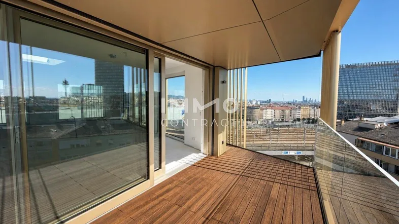 Großer Balkon mit Holzboden und Glasgeländer bietet einen weiten Blick über die Stadt.